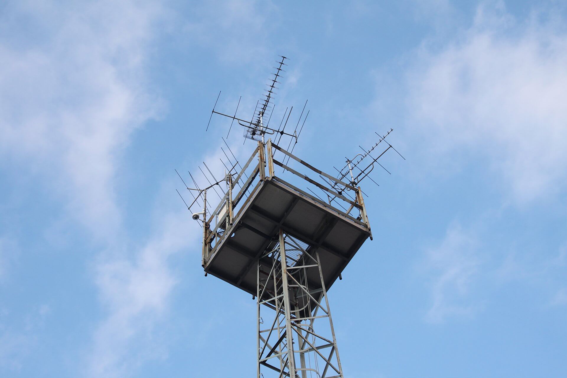 Anntennen auf einem Mast vor blauem Himmel